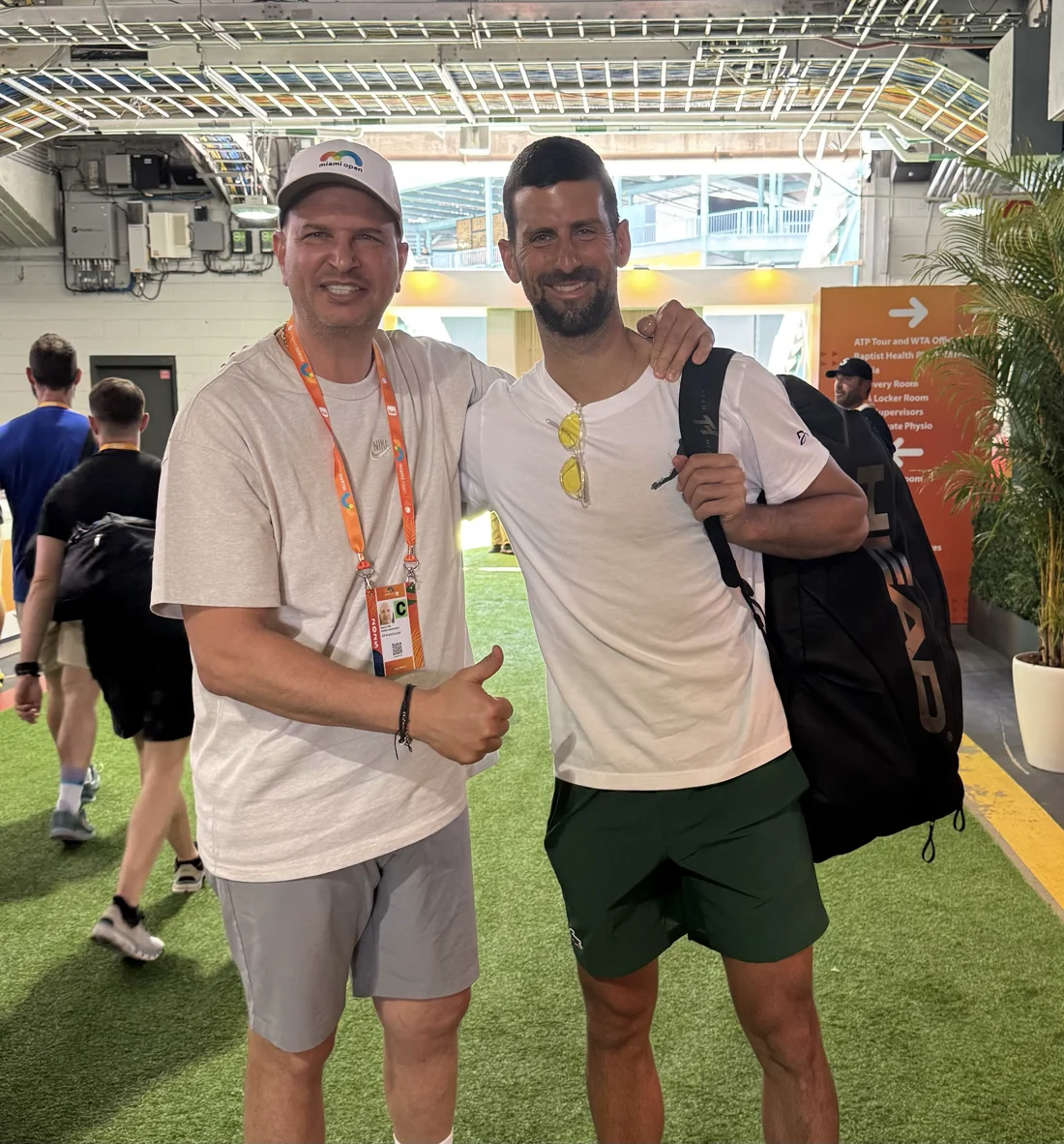 Novak Djokovic reviewing his custom orthotics with Tamir Kfir on a tennis court